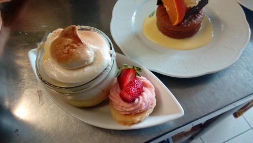 two plates of desserts with strawberries on them on a table at Chez Louis chambres d'hôtes à la ferme in La Canourgue