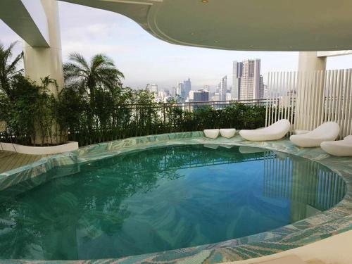 a swimming pool on the roof of a building at Oasis Regency @ Acqua Livingstone near Rockwell in Manila