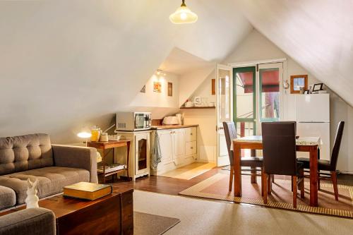 a living room with a table and a kitchen at Crabtree House in Huonville