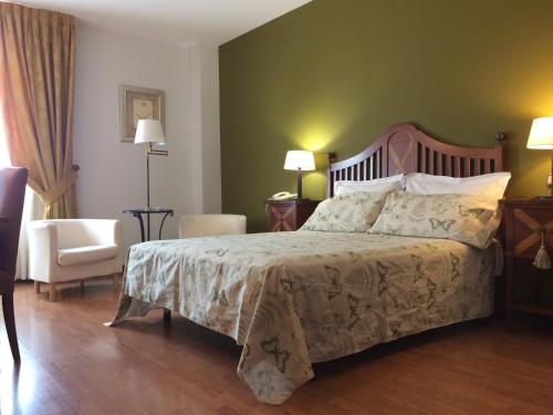 a bedroom with a bed and a couch and a chair at Hotel Villa De Ferias in Medina del Campo