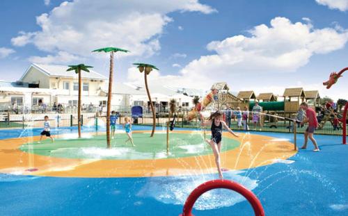 a group of people playing in a water park at Caravan by the sea Trecco Bay in Porthcawl