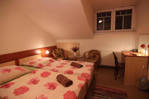 a bedroom with a bed and a table and a desk at Hotel Restaurant Svejk in Bublava