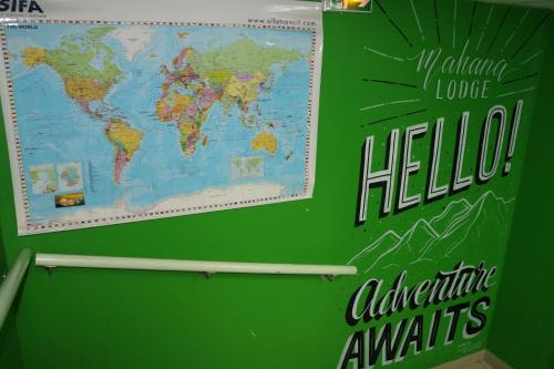 a green board with a map of the world on it at Mahana Lodge Hostel & Backpacker in Papeete