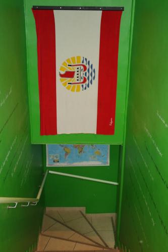 a flag is hanging in a green room at Mahana Lodge Hostel & Backpacker in Papeete