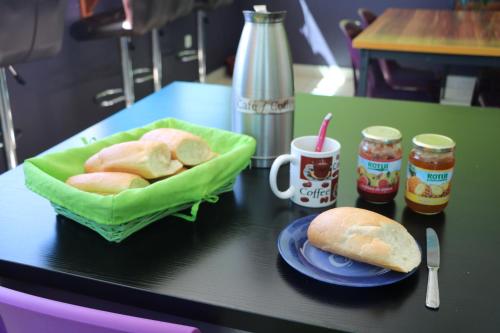 
a plate of food on a table next to a cup of coffee at Mahana Lodge Hostel & Backpacker in Papeete
