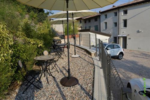 patio con tavolo e ombrellone di Spagnoi Rooms a Castelnuovo del Garda