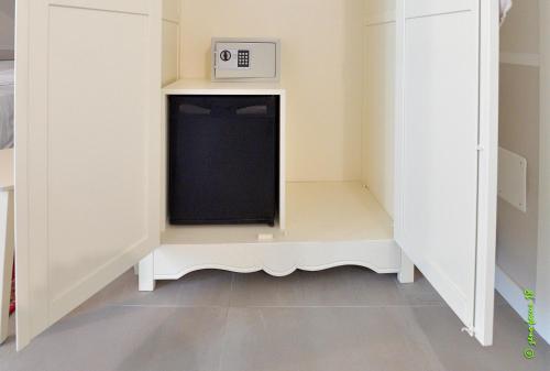 a walk in closet with a microwave and a tv at Spagnoi Rooms in Castelnuovo del Garda