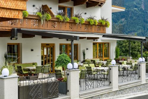 a hotel with a patio with tables and chairs at Platzlhof - Mein Hotel im Zillertal in Ried im Zillertal