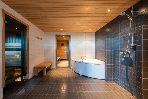 a large bathroom with a tub and a shower at Rukavuorenhuippu Apartment in Ruka