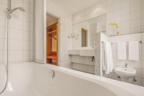 W łazience znajduje się wanna, umywalka i lustro. w obiekcie Best Western Plus Hotel Excelsior w mieście Erfurt