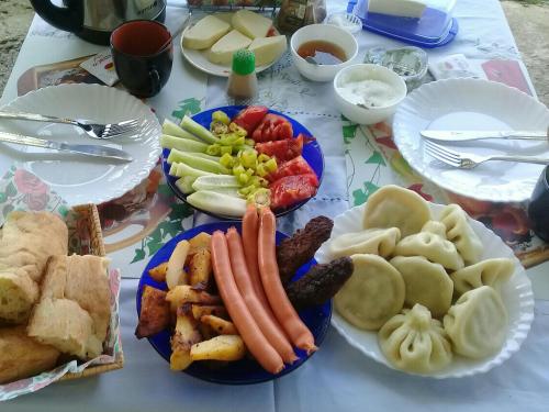 a table topped with plates of food with vegetables and meats at Apartment Giorgi in Sighnaghi in Sighnaghi