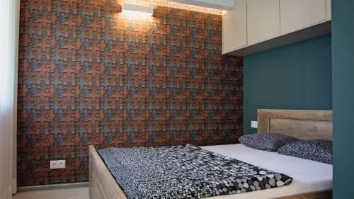 een slaapkamer met een bakstenen muur en een bed bij Apartament Piano 3 in Racibórz