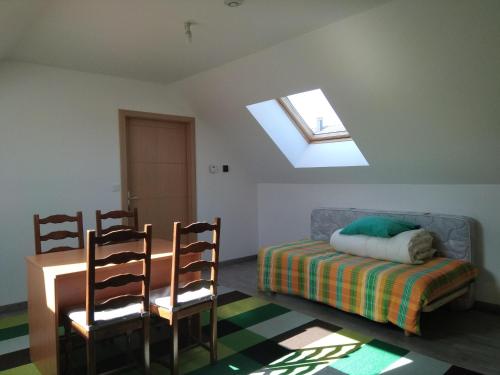 a bedroom with a bed and a skylight and two chairs at Etape au Calme à 4Km du Center de Reims in Reims