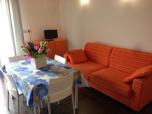 un soggiorno con divano e tavolo con fiori di Residence Antares a Caorle