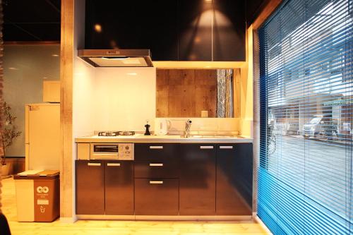 a small kitchen with a sink and a window at Kazemachigusa INN in Osaka