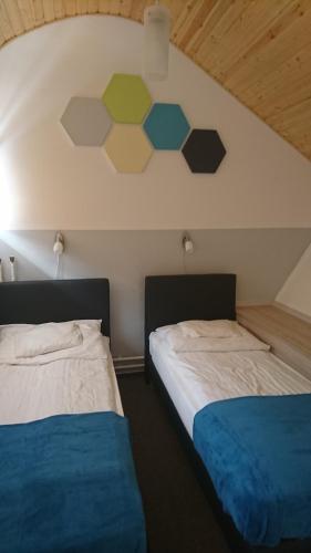 two beds sitting next to each other in a room at Hőforrás Hotel in Gyula