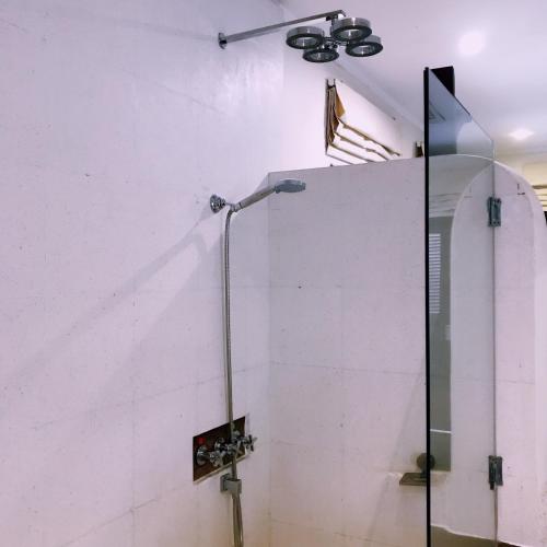 a shower in a room with a white wall at Ancient Luangprabang Hotel in Luang Prabang