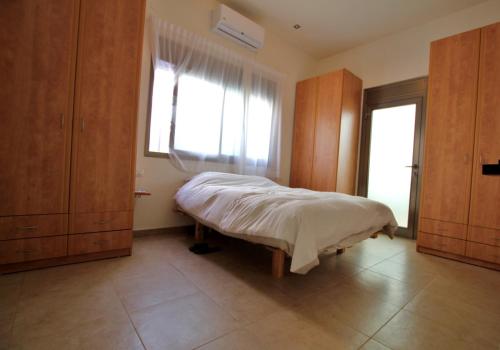 a bedroom with a bed and a large window at Tlv Hayarkon 88 in Tel Aviv