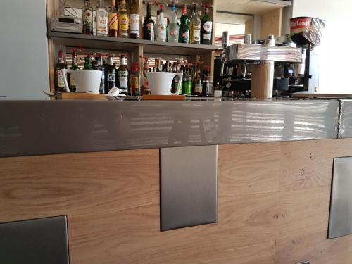 a bar with a counter with alcohol bottles at Logis Hotel Schaeffer- Restaurant Le Saint Georges in Serrières