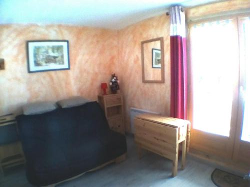 een kamer met een bank, een tafel en een raam bij Appartement Pyrénées 2000 in Font-Romeu