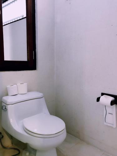 a bathroom with a white toilet and a window at Ancient Luangprabang Hotel in Luang Prabang