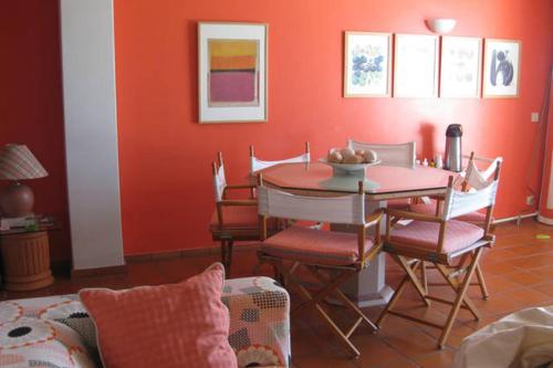 a dining room with a table and chairs and red walls at Montanha, rio e mar... in Vila Nova de Cerveira
