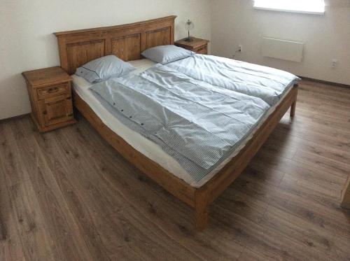 1 cama grande en un dormitorio con suelo de madera en Apartmán Sulov, en Staré Hamry