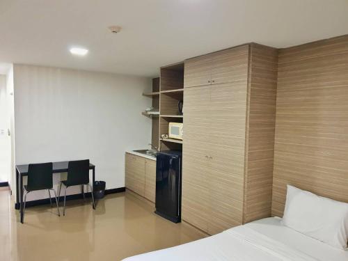 a bedroom with a bed and a kitchen with a microwave at Mooks Residence in Pattaya