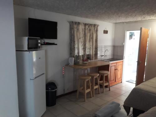 a kitchen with a refrigerator and a counter with stools at 29 Polvy Street in Nelspruit