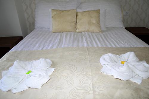 a bed with two towels on top of it at Hotel Írisz in Nyíregyháza