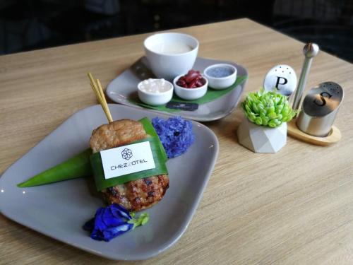 a table with two plates of food on a table at Chezzotel Pattaya in Pattaya Central