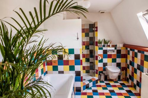 ein farbenfrohes Bad mit einer Badewanne und einem WC in der Unterkunft The Livingrooms Laren in Laren