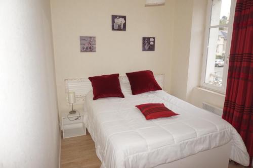 カンカルにあるT3 Calme et Lumineux entre mer et centre bourgの白いベッド(赤い枕付)が備わるベッドルームです。