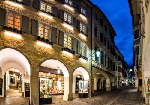 a building with arches on a street at night at Guesthouse Suiteseven in Merano