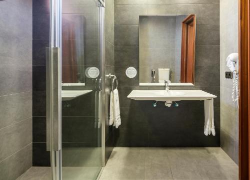 a bathroom with a sink and a shower at Ilunion Golf Badajoz in Badajoz