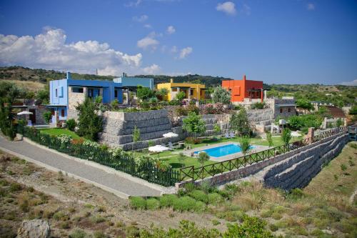 a house on a hill with a yard and a pool at Petroto Villas in Kiotari