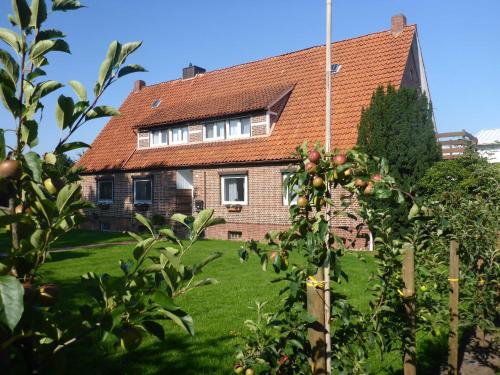 a house with a green yard with an apple tree at Ferienwohnung Werner in Jork