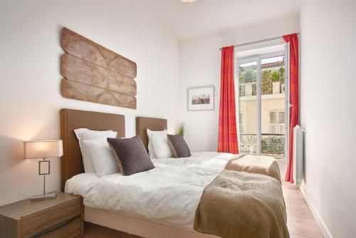 a bedroom with a large bed and a window at Le Nomad in Nice