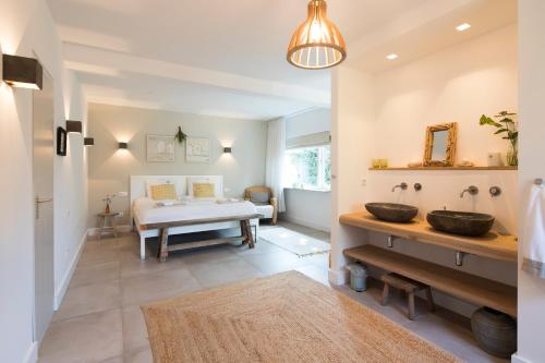 een badkamer met een wastafel en een bed in een kamer bij Het Ockhuis in Moergestel