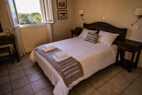 a bedroom with a bed with two towels on it at Maria's Place - Adults Only in Oia
