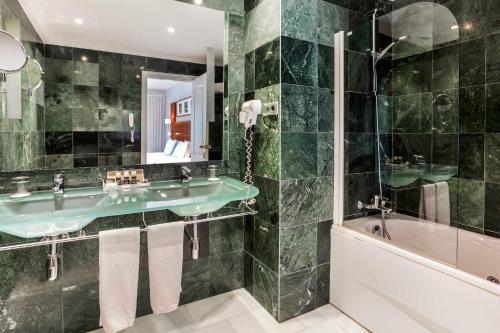 a bathroom with a green sink and a tub at Exe Las Adelfas in Córdoba