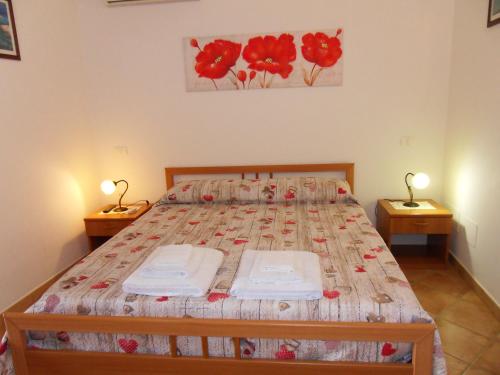 ランペドゥーザにあるAppartamento Girasoleのベッドルーム1室(ベッド1台、タオル2枚付)
