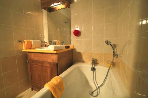 ein Badezimmer mit einer Badewanne und einem Waschbecken in der Unterkunft travelski home select - Résidence L'Arollaie 4 stars in Peisey-Nancroix