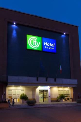 a hotel and shuttle sign on the side of a building at City Hotel & Suites in Foligno