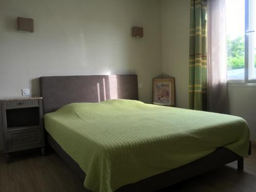 タルノスにあるMaison entre côte basque et côte Landaiseのベッドルーム1室(緑の毛布付きのベッド1台付)