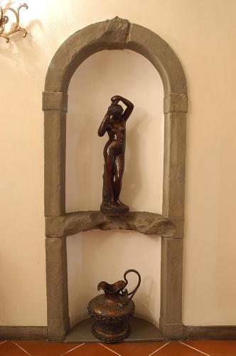 a statue of a woman on a shelf with a vase at Hotel Martelli in Florence