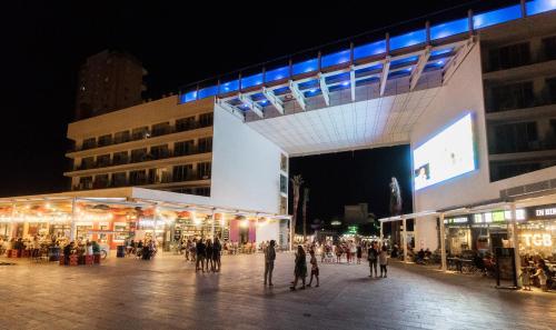 a group of people walking around a street at night at INNSiDE by Meliá Calviá Beach in Magaluf