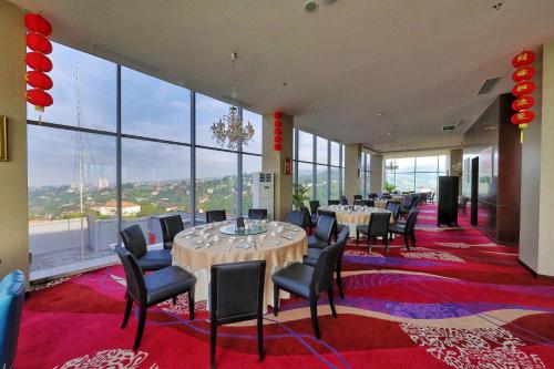 a restaurant with tables and chairs and large windows at InterContinental Bandung Dago Pakar by IHG in Bandung