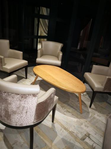 a group of chairs and a wooden table and chairs at Mmakgabo Boutique Lodge in Bela-Bela