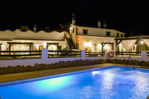 una piscina frente a una casa por la noche en Cuevas El Moral, en Castilléjar